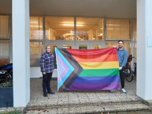 Twee docenten houden regenboogvlag vast