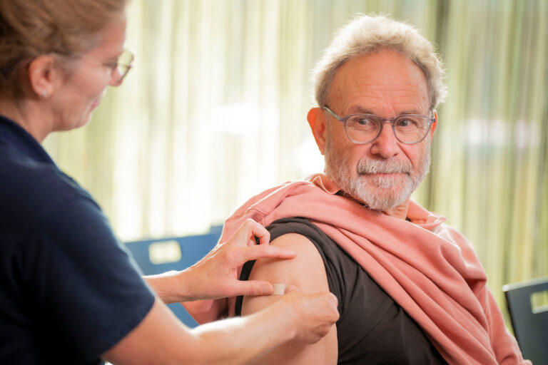 Een man krijgt een coronaprik in zijn arm
